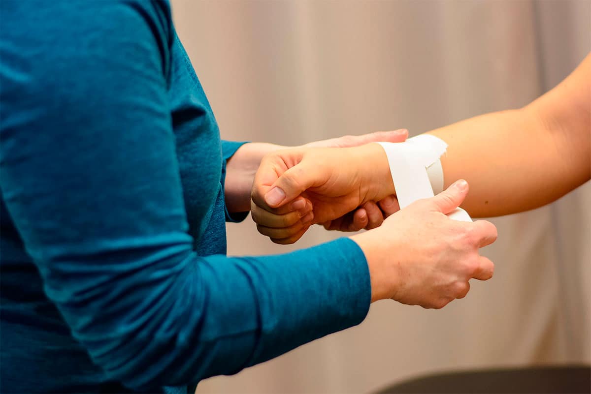 Kvinde der viser hvordan man taper håndled op